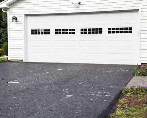 A classic white raised-panel door with windows, expertly serviced by a professional garage door repair Austin TX team.